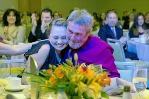 Kristin Day and her father, Dennis, giving a side hug at the table