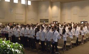 LECOM Bradenton First Year College of Medicine Student standing during white coat ceremony in Bradenton, Florida.