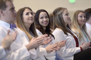 Close up view of students clapping in LECOM Erie's white coat ceremony. 