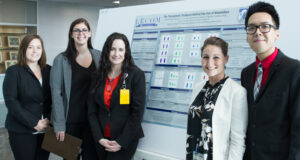 Brandi Conely, Kelly Fero, Stephanie Wills and Johnny Le Nguyen, stand with faculty mentor Victoria Reinhartz, Pharm.D., in front of the group’s winning poster presentation.