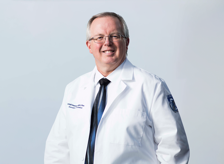 Older male doctor in white coat, tie, and glasses at LECOM