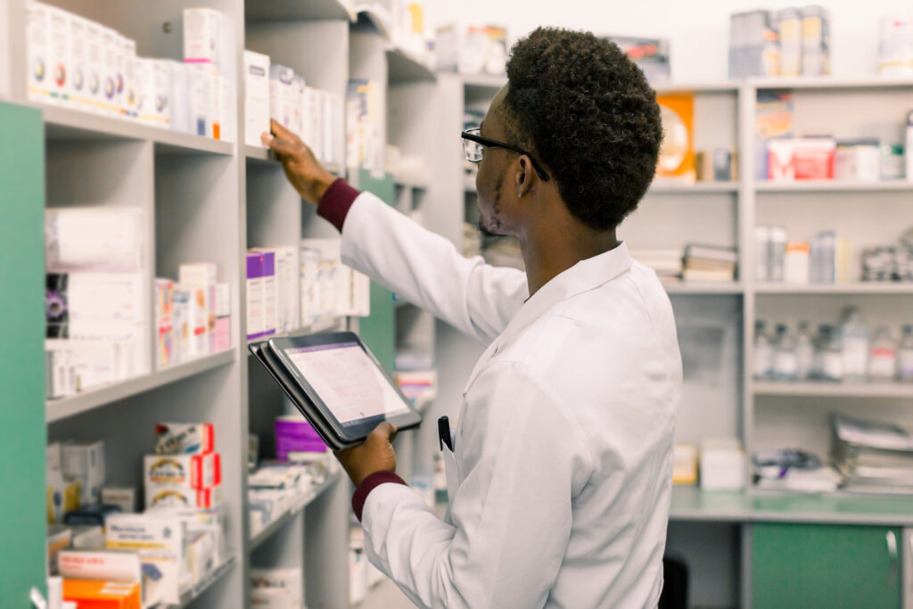 Confident African American man pharmacist standing in interior of pharmacy