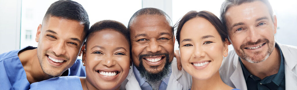 Medical, portrait of doctors and happy together at hospital or clinic with smile. Diversity, medical team for healthcare and excited or cheerful group of nurse or surgeons smiling for health wellness.