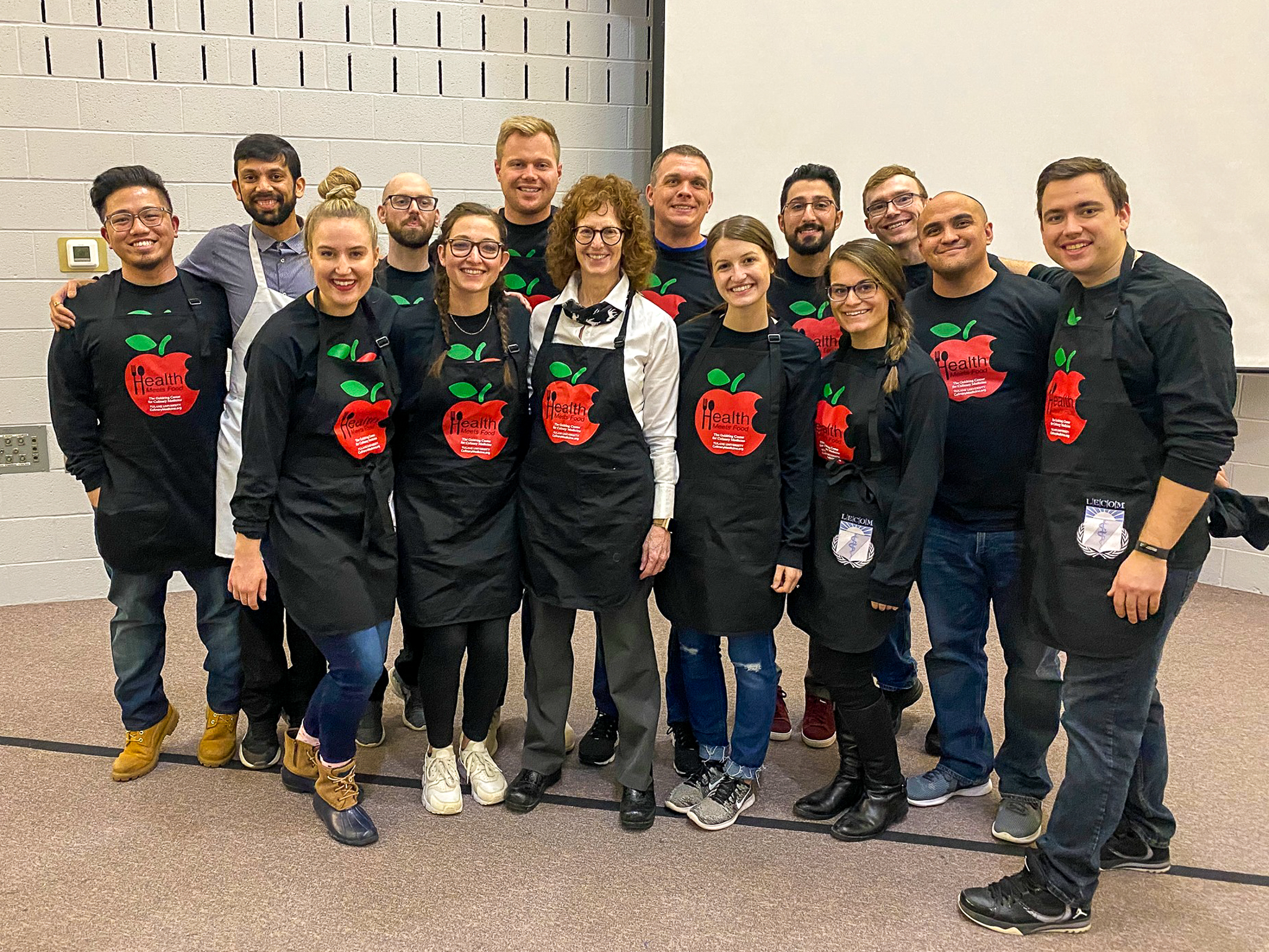 LECOM medical students and instructor in Healthy Kitchens culinary training aprons