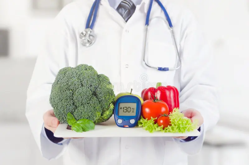 Doctor holding a tray of fresh vegetables and a blood glucose meter